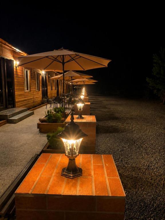 a group of tables with umbrellas at night at Tornikes Cottages in Ureki