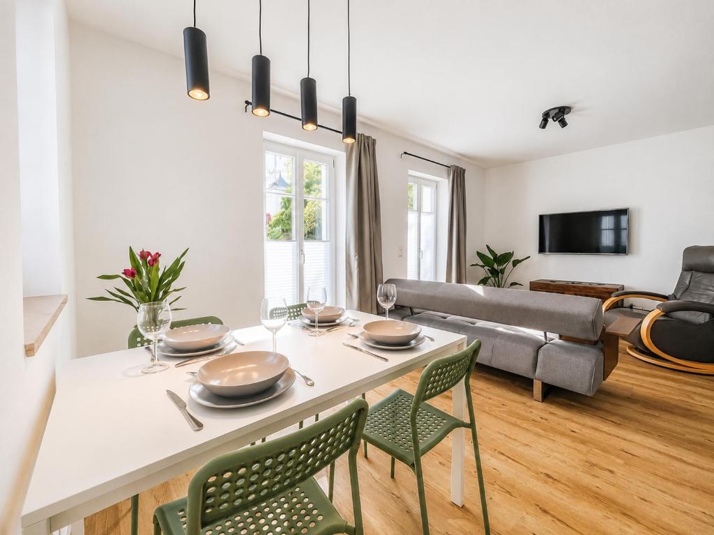 a living room with a table and chairs and a couch at SCHEE Apartments - stilvolle & zentrale Wohnungen mit Privatparkplatz in Nördlingen