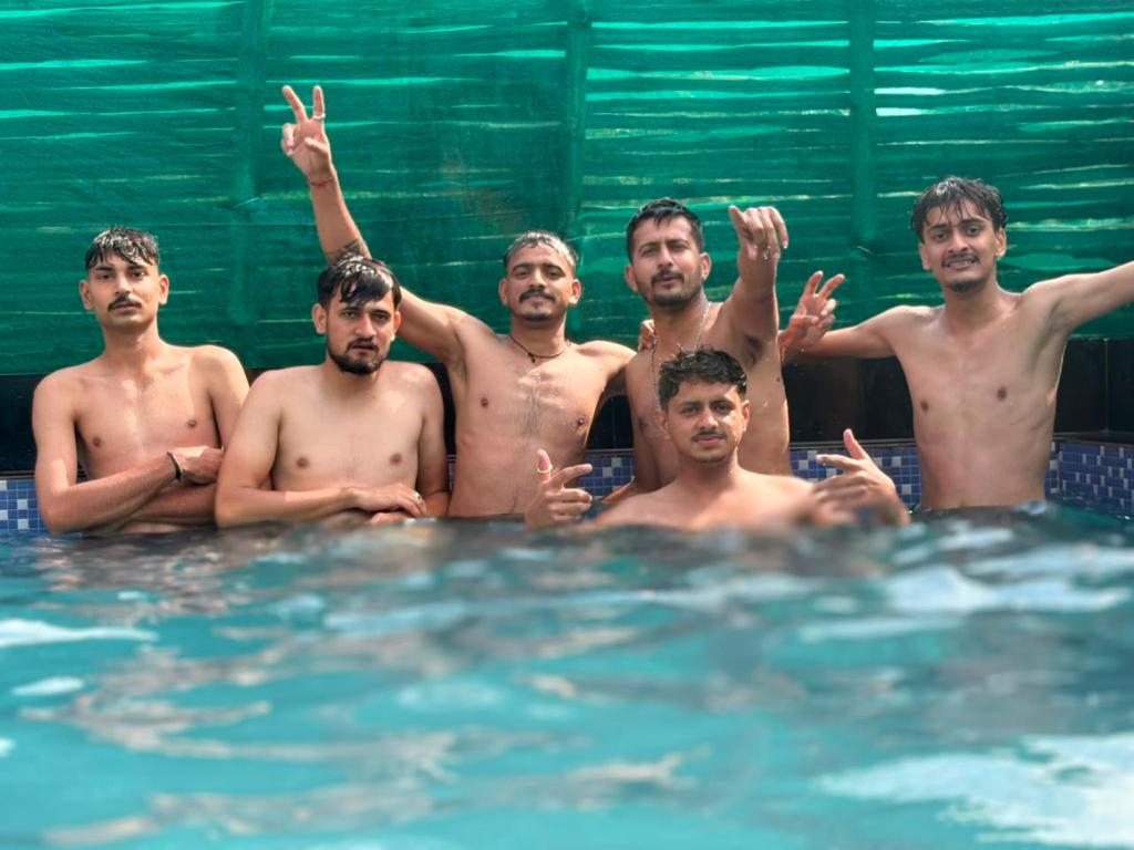 a group of men standing in a swimming pool at Himjoy farm in Dādo Sība