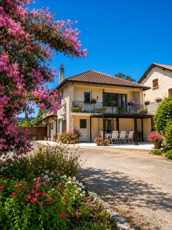 a house with chairs and flowers in front of it at Gîte Chez Julie - Clima - Parking in Sarlat-la-Canéda
