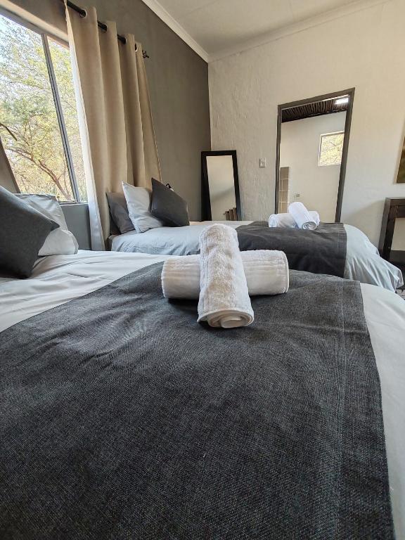 two beds with towels on them in a bedroom at Masango Lodge in Hoedspruit