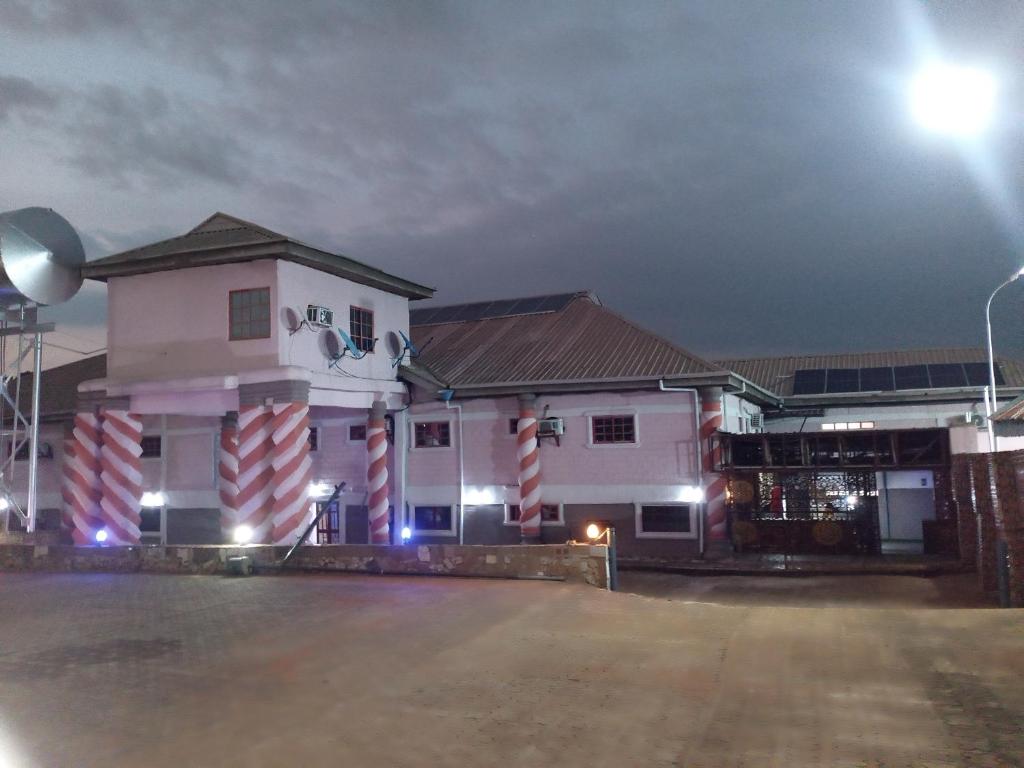 a white building with a street light in front of it at Zim Zam View Hotel in Onitsha