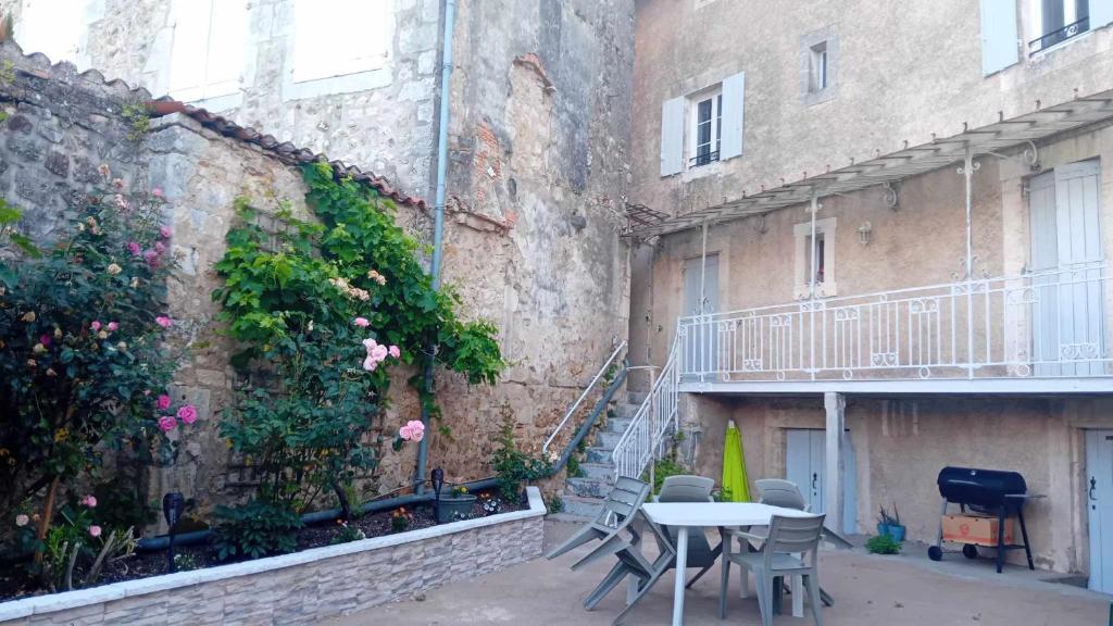 a patio with a table and chairs next to a building at Charming house in Montbron