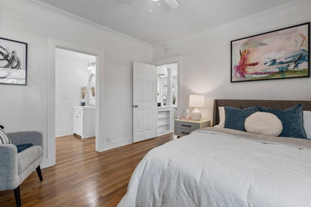 a white bedroom with a bed and a chair at Le Willow-VintageModern Design in Modesto