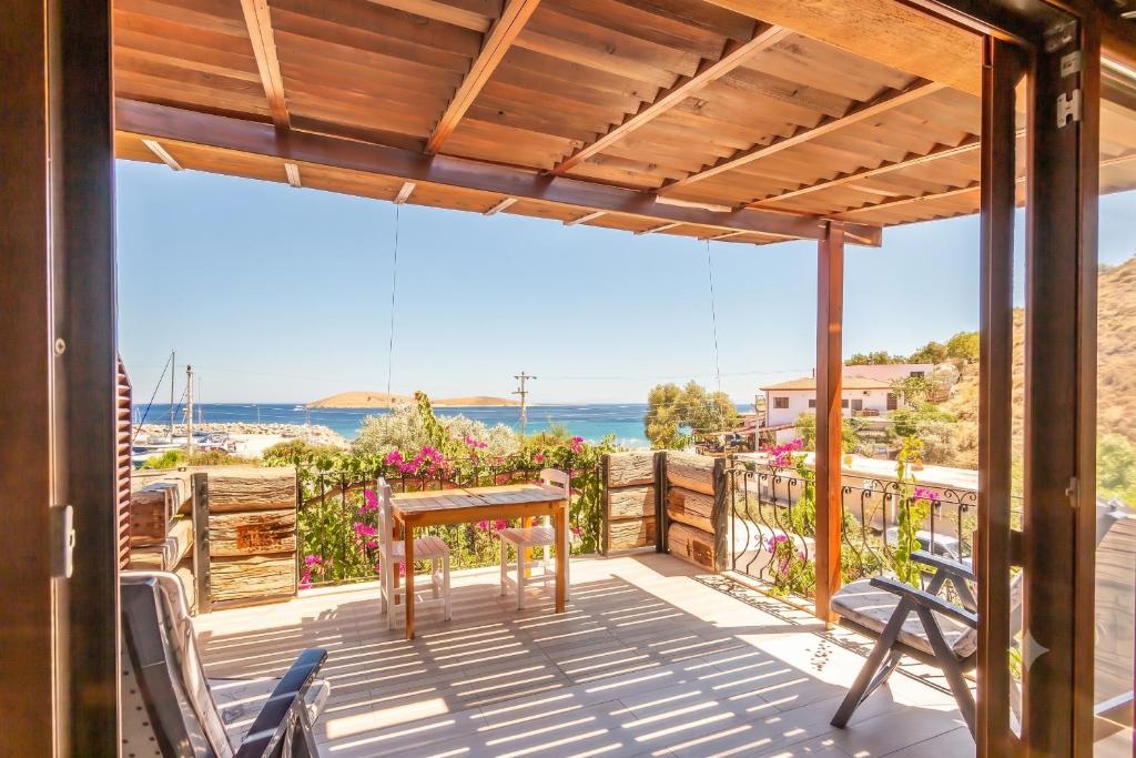 a patio with a table and chairs on a deck at Liman Pansiyon Palamutbükü in Datca