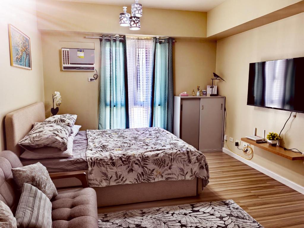a bedroom with a bed and a flat screen tv at New OneHeart Avida Riala T5 Condo in Cebu City