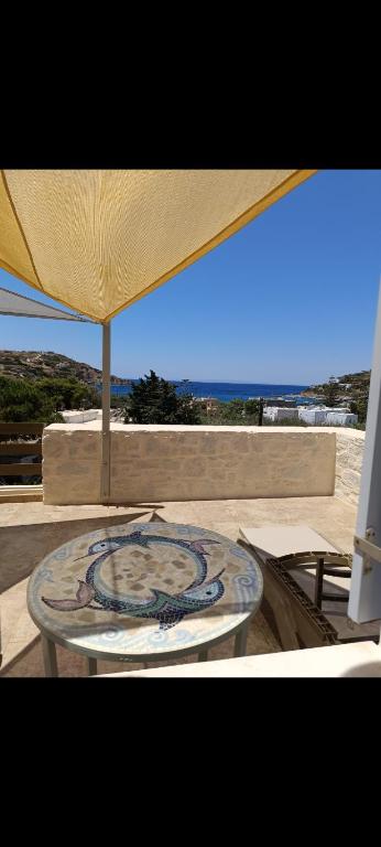 a table under an umbrella on a patio at Mosaic house by the sea in Kini