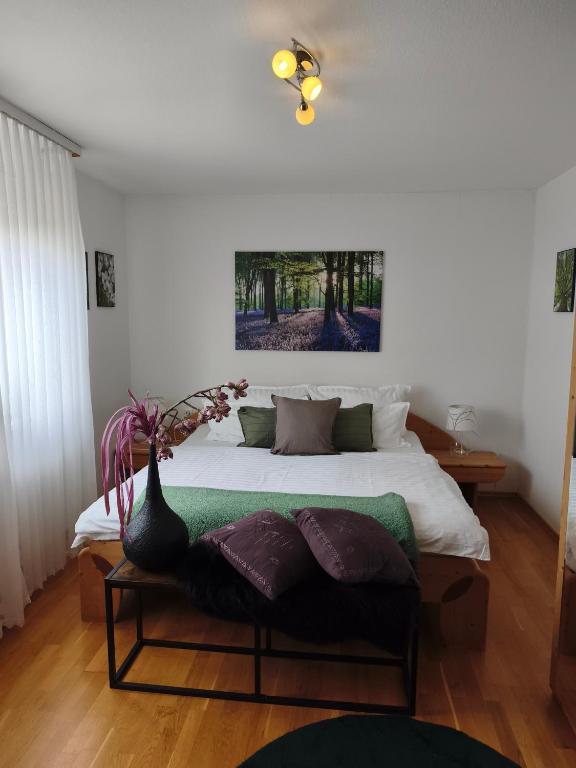 a bedroom with a bed with a vase on a table at Fewo Sartorius in Bensheim