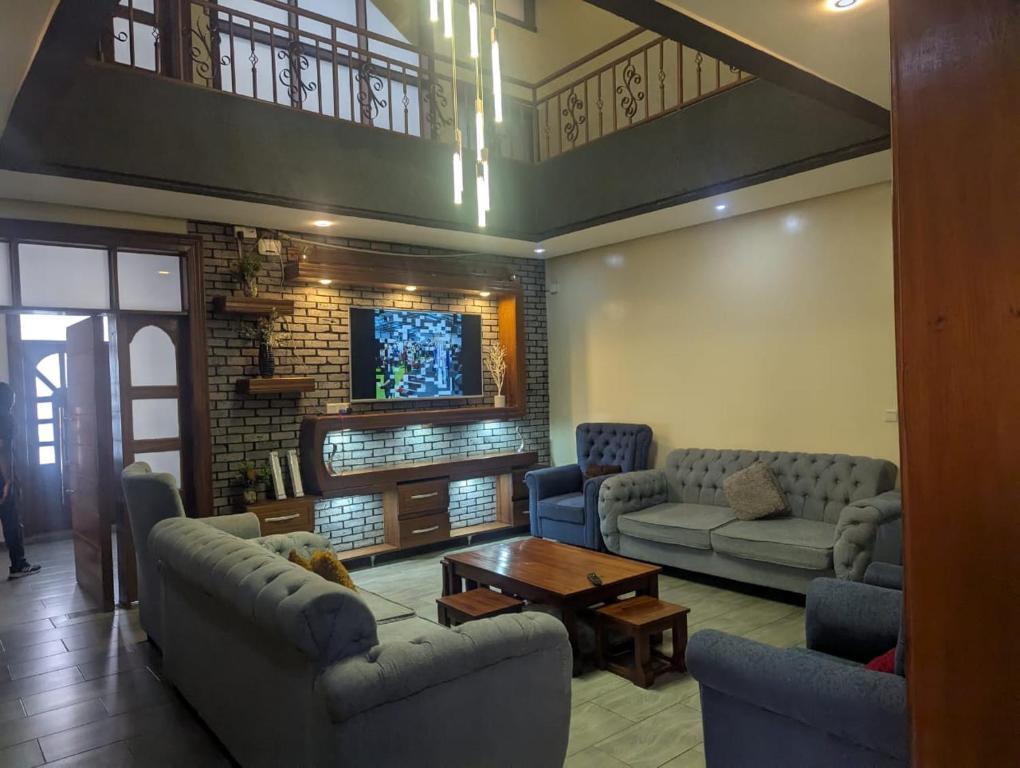 a living room with couches and a table at Royce's Apartment in Kigali