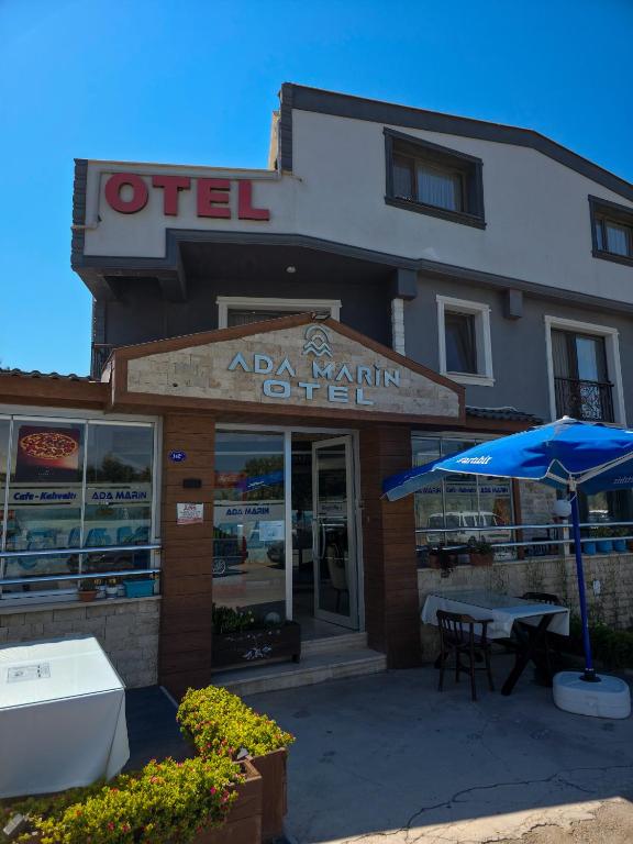 a restaurant with a blue umbrella in front of it at Ada Marin Hotel in Urla