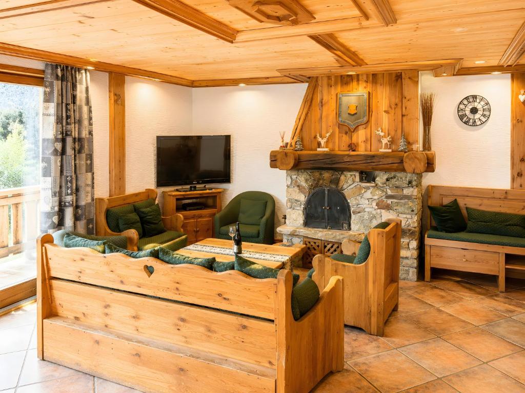 a living room with a fireplace and a tv at Les Dolomites in La Plagne Tarentaise