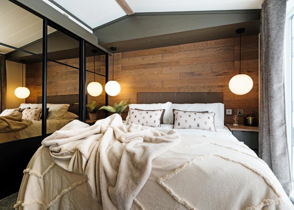 a bedroom with a large bed and two mirrors at Monarch Lakes in Boston