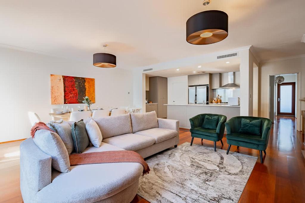 a living room with a couch and two green chairs at Family Friendly, Stylish Floreat, Pool in Perth