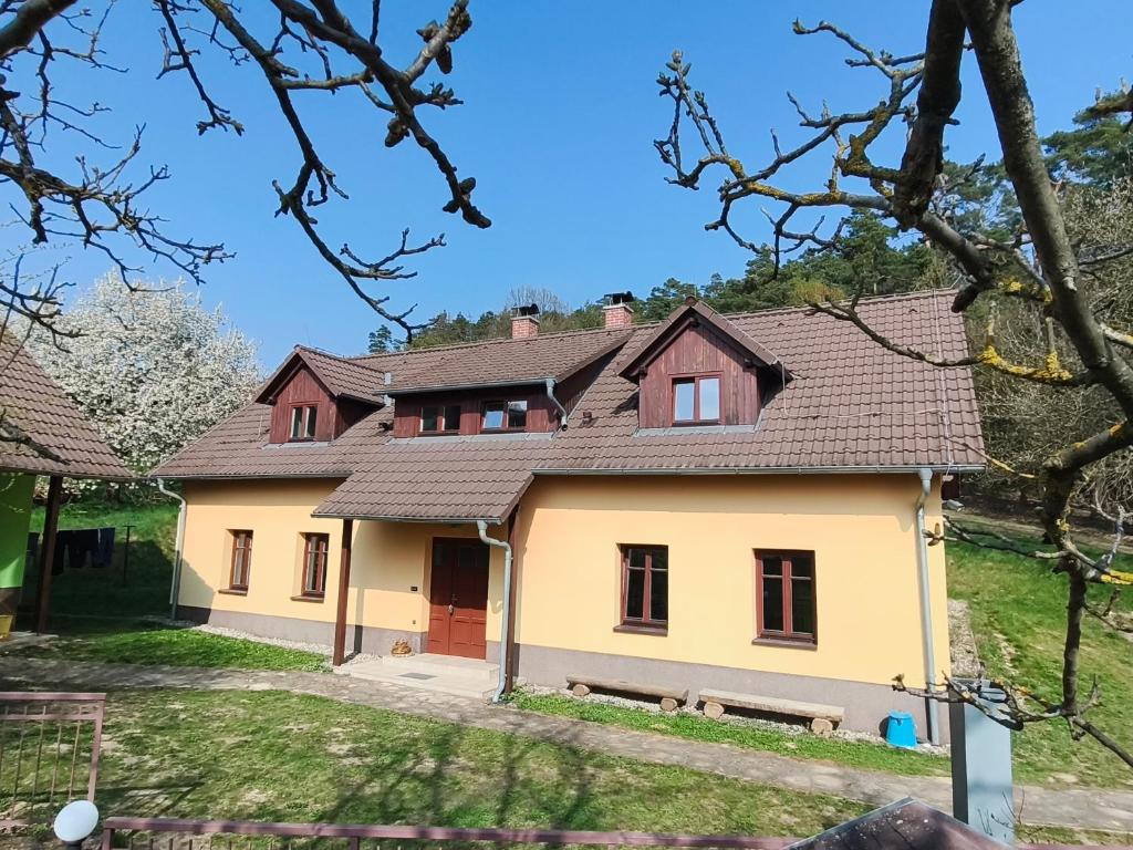 a yellow house with a brown roof at Na pasekách u lesa apartmán Radost in Osvětimany