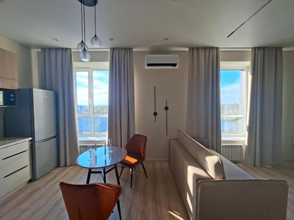 a living room with a couch and a table with chairs at Central Avenue in Karagandy