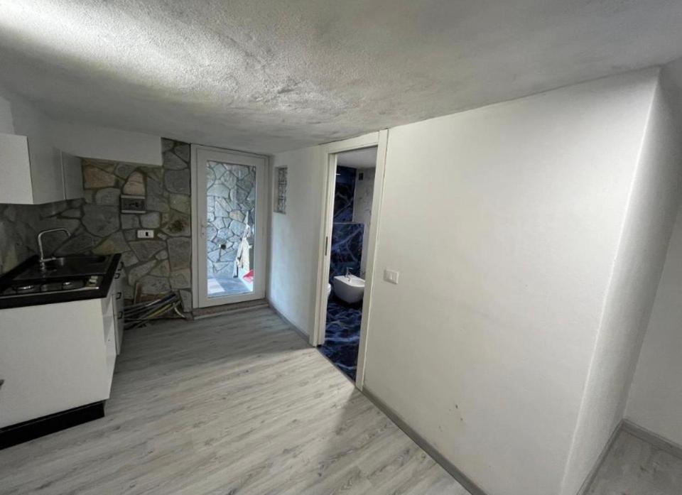 an empty kitchen with a counter and a door to a bathroom at Il Bunker in Bolano
