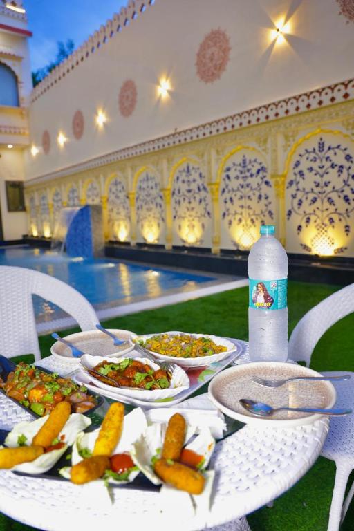 a table with plates of food and a bottle of water at Hotel Cyra palace in Jaipur