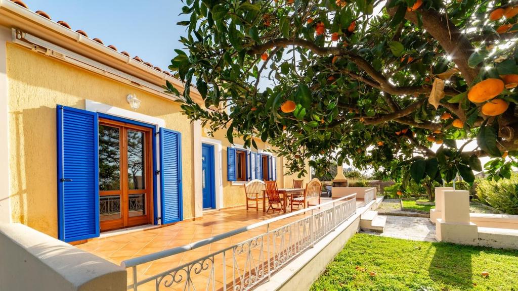 a house with a deck with blue shutters at Villa Katerina BBQ & pool! in Metaxáta