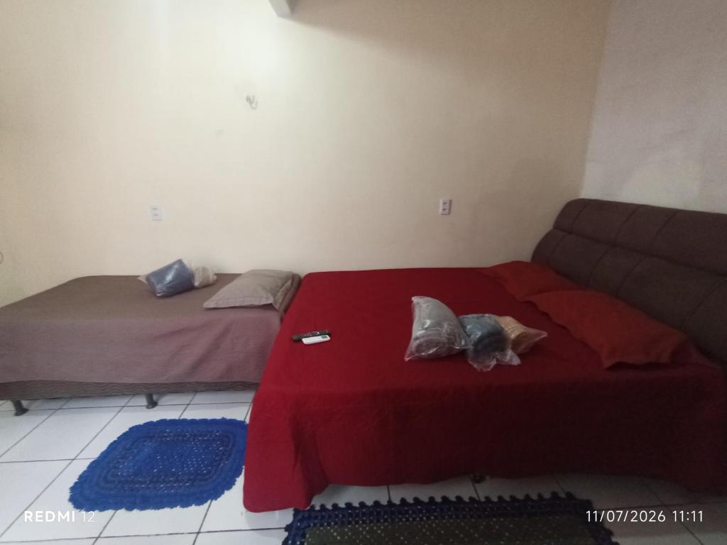 a bedroom with two beds and a red blanket at kit Net no Vinhais in São Luís
