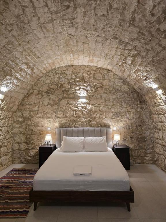 a bedroom with a bed in a stone wall at Estia Mylona in Ayios Therapon