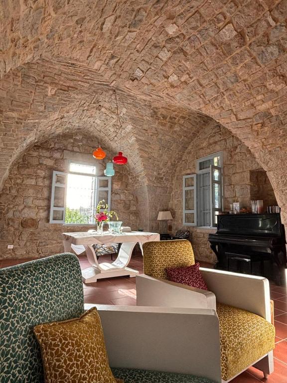 a living room with a couch and a piano at Dar el Maasser دار المعاصر in Maasser El Chouf