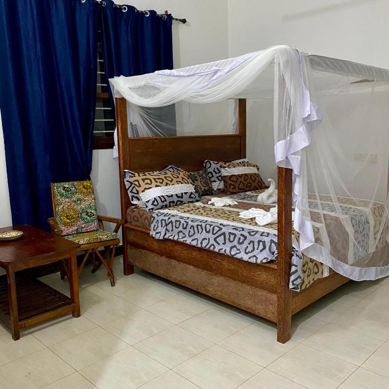 a bedroom with a bed with a canopy at Fish House in Nungwi