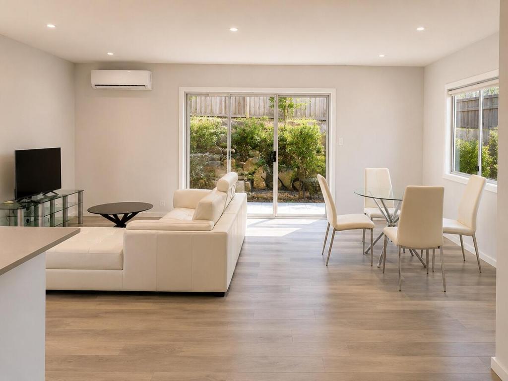a living room with a white couch and a table at 18 Pimpama Home in Pimpama