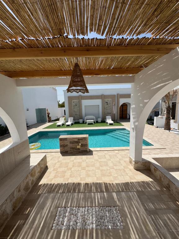 a large swimming pool with a wooden ceiling at Villa Mazzyd in Temlale