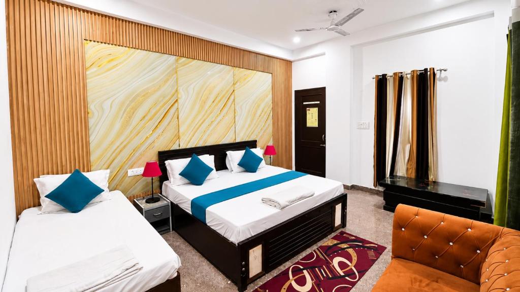 a hotel room with two beds and a chair at Hotel Radha Rani Bhawan in Vrindāvan