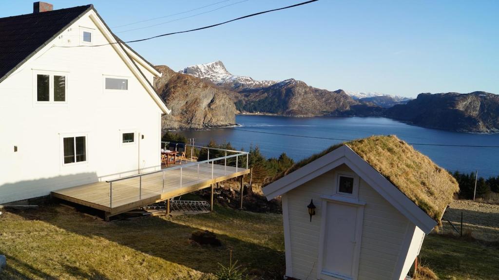 a white house with a roof with a dock at Kvalheim Nordfjord in Myre