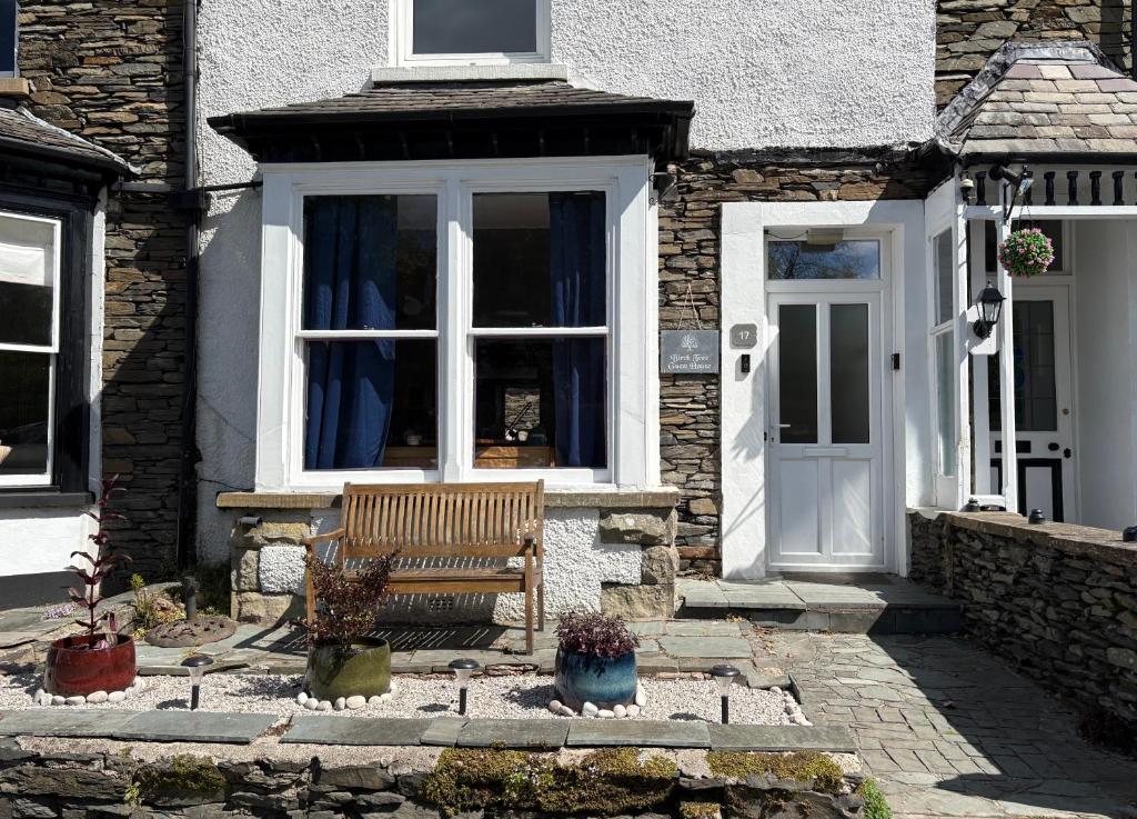 a wooden bench sitting in front of a house at Birch Tree House in Windermere