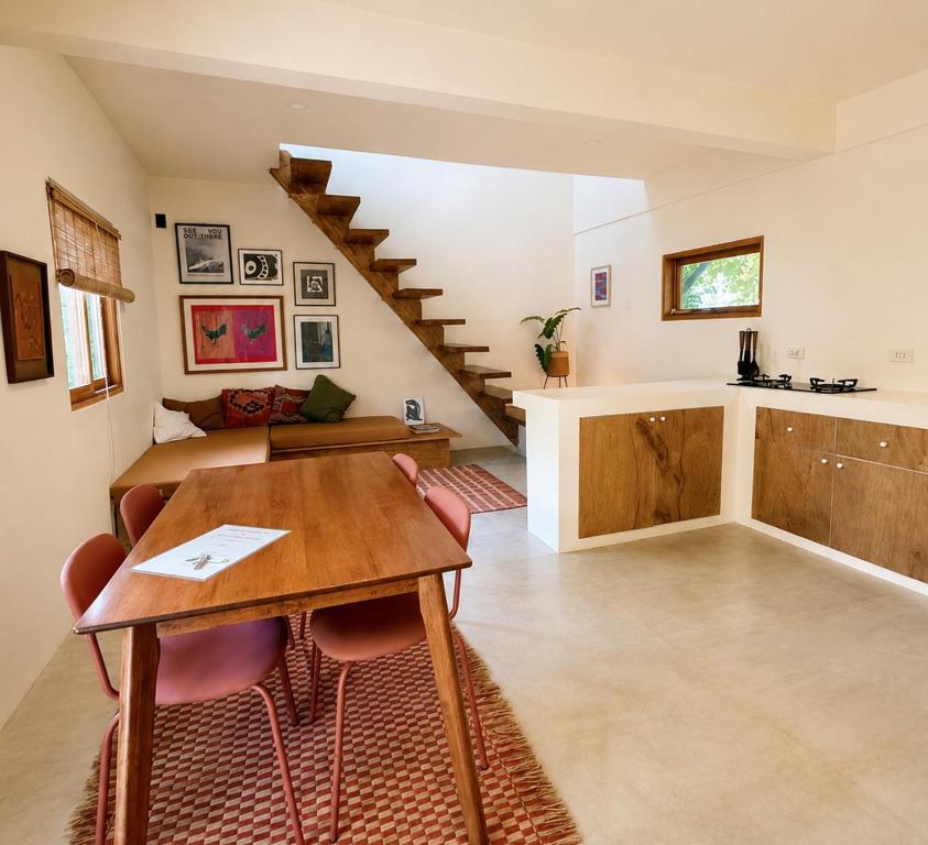 a living room with a table and a kitchen at Surfer's Hideout - central two-storey HOUSE with garden & private balcony in General Luna