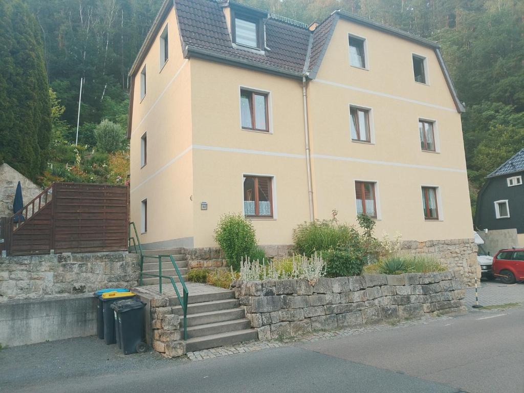 a house with a stone wall and stairs in front of it at Gohrischstein Blick in Rathmannsdorf