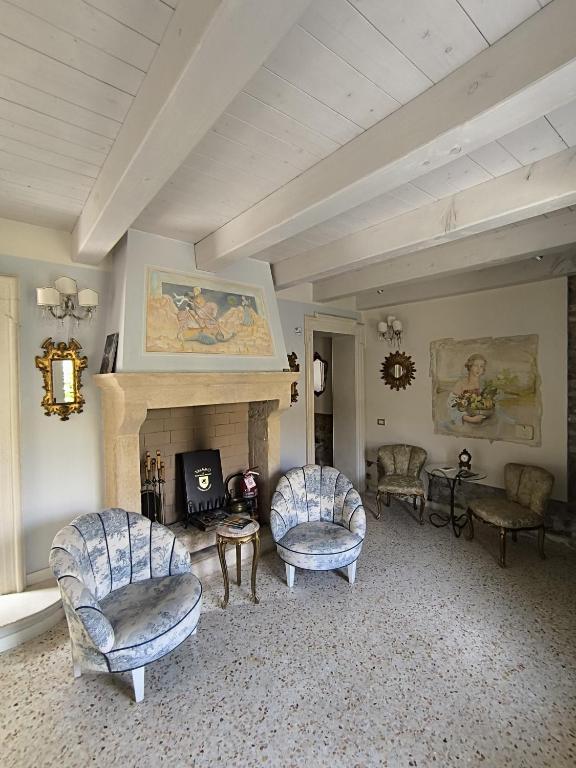 a living room with two chairs and a fireplace at Talamo Rooms in San Martino Buon Albergo