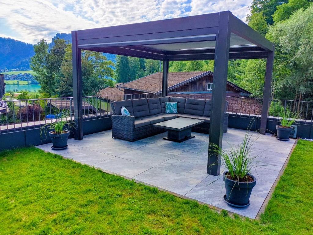 a pergola with a couch on a patio at PS-Apartment Luis in Vorderthiersee