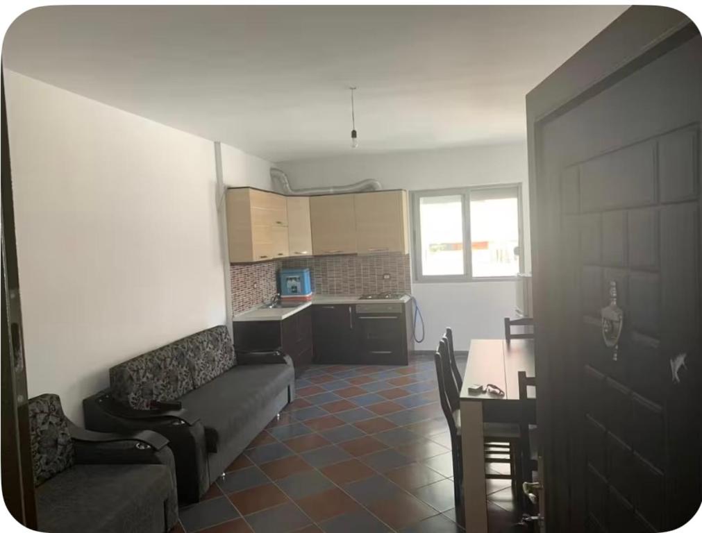 a living room with a couch and a table and a kitchen at Adriatic Pearl Apartaments in Lezhë
