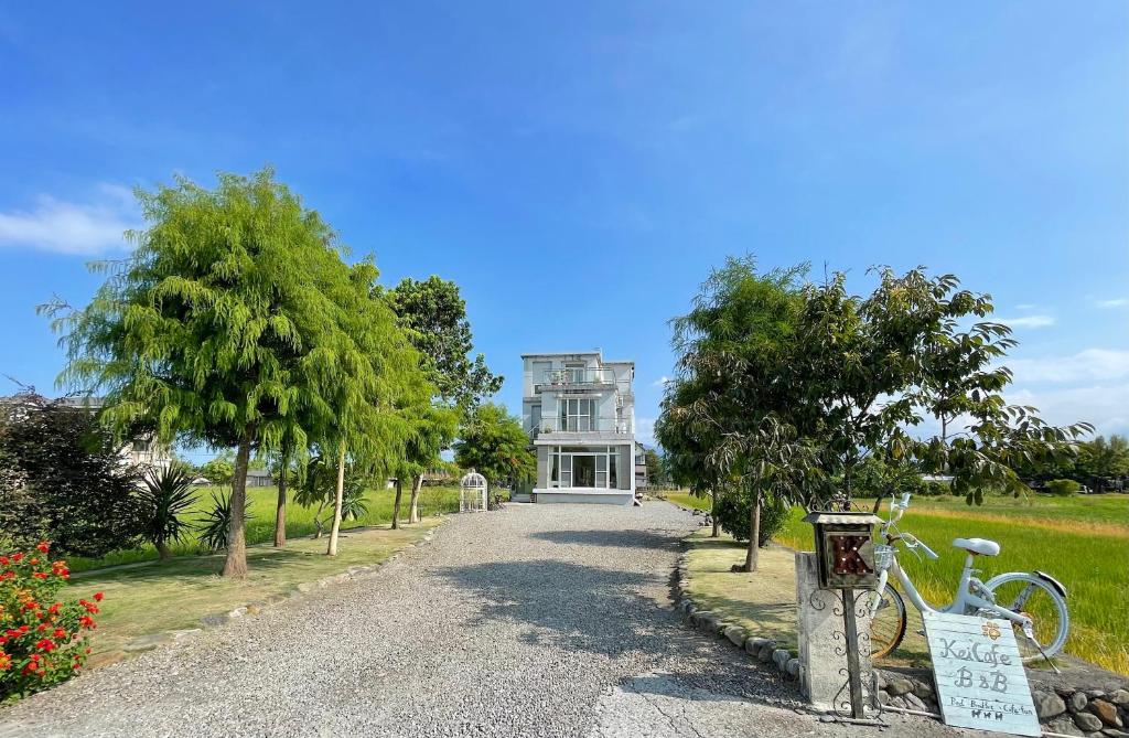 a white house with a bike parked in front of it at 小k咖啡B&B 寵物友善 咖啡廳民宿 in Sanxing