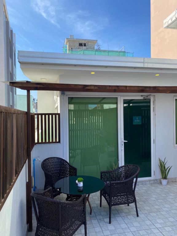 a patio with a table and chairs on a balcony at Studio Apartment on a Terrace by Skysuites in Male City