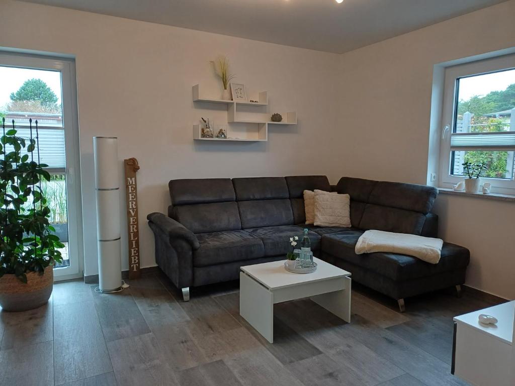 a living room with a black couch and a table at Ferienwohnung BlumenMeer in Karlshagen