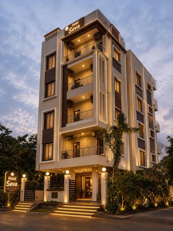 a large white building with stairs in front of it at Hotel Seva in Nagpur