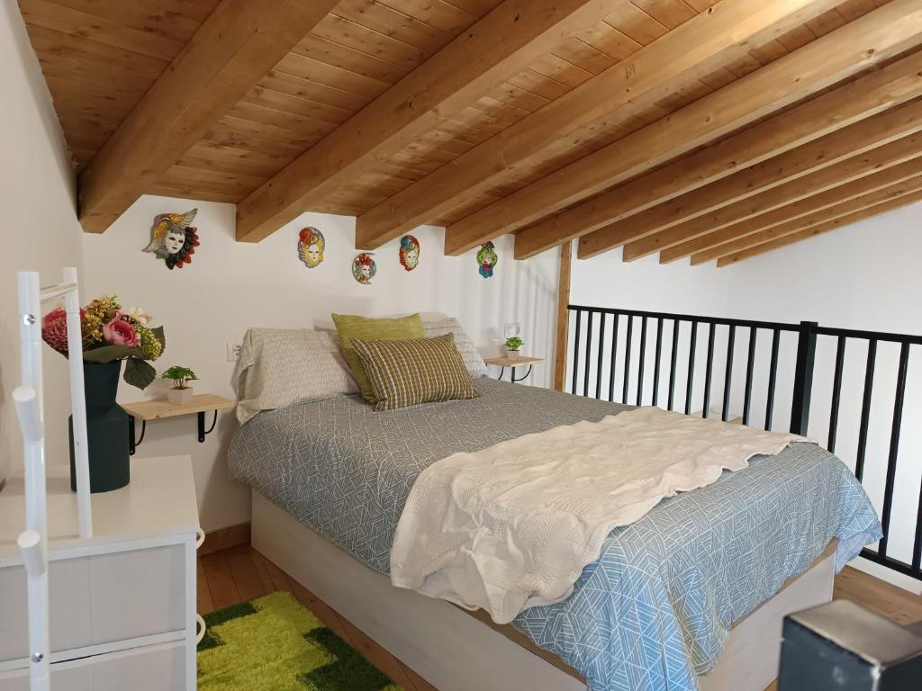 a bedroom with a bed and wooden ceilings at Casa Do Renque in Arzúa