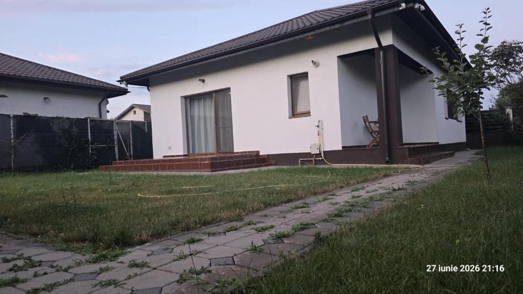 a white house with a stone path in front of it at Casa Magurele in Măgurele