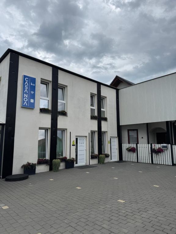 ein weißes Gebäude mit einem blauen Schild darauf in der Unterkunft Casa Noa in Marginea