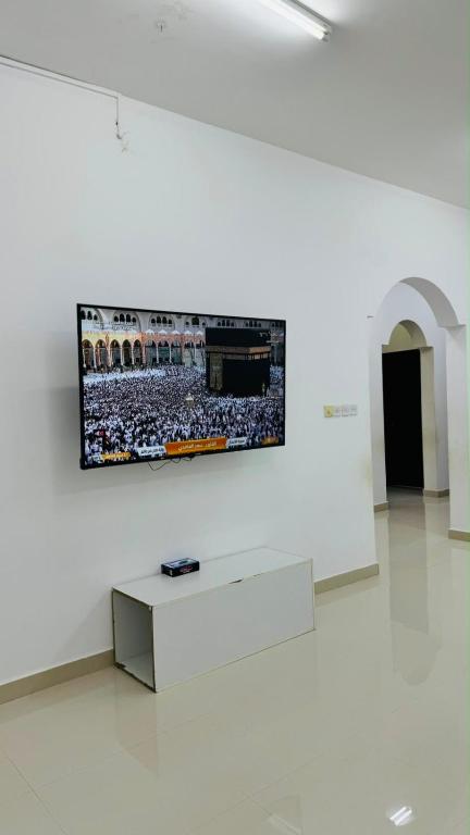 a flat screen tv on a wall in a white room at فيلا in Salalah