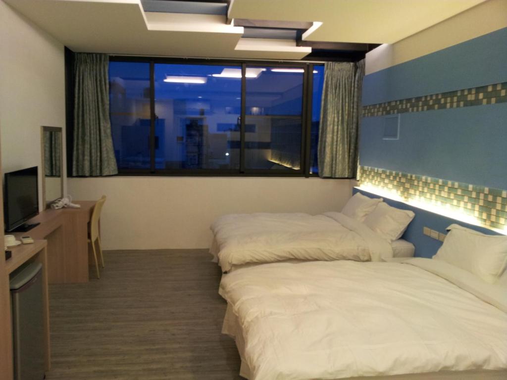 馬公市的住宿－哈利路亞民宿，带大窗户的客房内的两张床