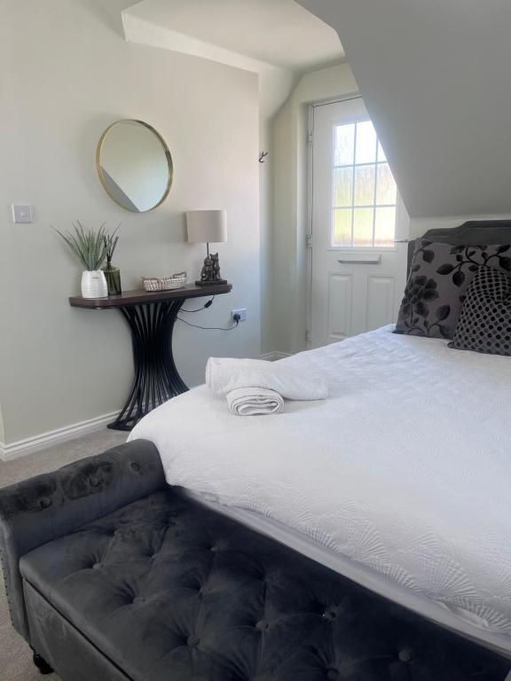 a bedroom with a large bed with a mirror on the wall at Loft Studio in Davenham
