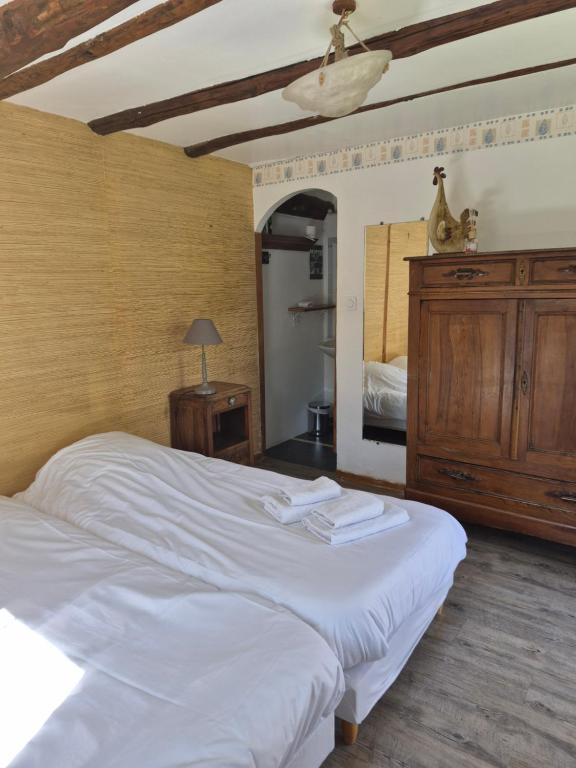 a bedroom with a large white bed and a mirror at Gîte de l'Escoutal La Vallée in Le Bleymard