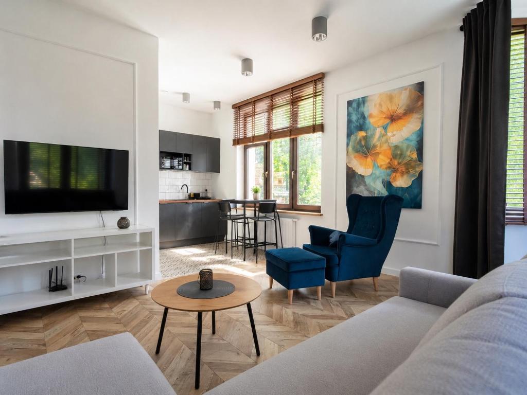 a living room with a couch and a tv at CanvasHome Apartamenty Aparthotel 250m od Rynku in Katowice