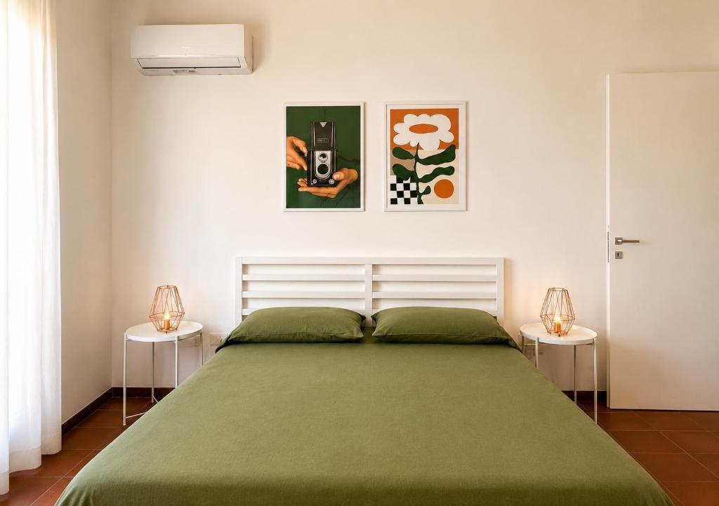 a bedroom with a large green bed with two lamps at GV Apartments in Caserta
