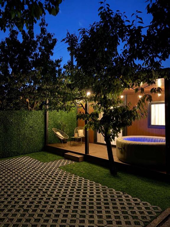 a garden with a tub and a tree in the yard at Feli Lodge in Bosanska Gradiška